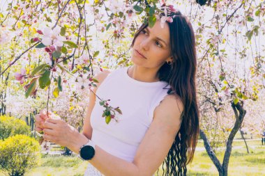 Kyiv 'deki Sakura bahçe parkında beyaz elbiseli güzel bir kadın.