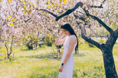 Kyiv 'deki Sakura bahçe parkında beyaz elbiseli güzel bir kadın.
