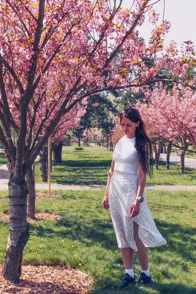 Kyiv 'deki Sakura bahçe parkında beyaz elbiseli güzel bir kadın.