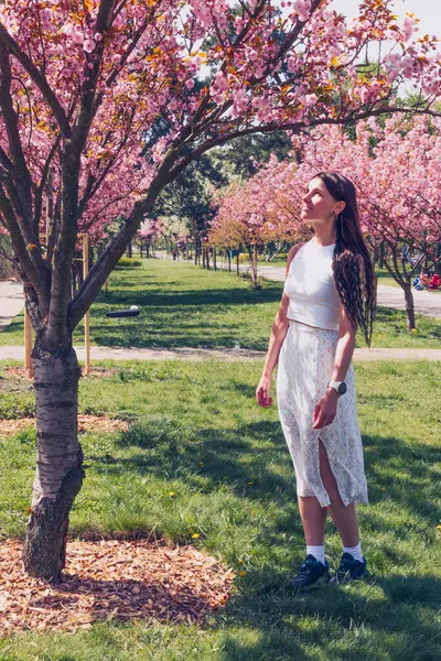Kyiv 'deki Sakura bahçe parkında beyaz elbiseli güzel bir kadın.