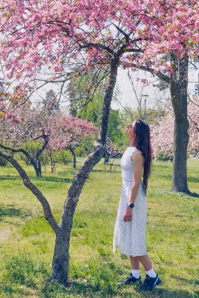 Kyiv 'deki Sakura bahçe parkında beyaz elbiseli güzel bir kadın.