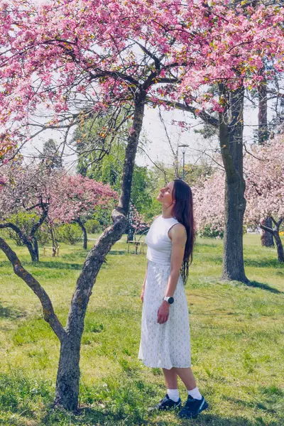 Kyiv 'deki Sakura bahçe parkında beyaz elbiseli güzel bir kadın.