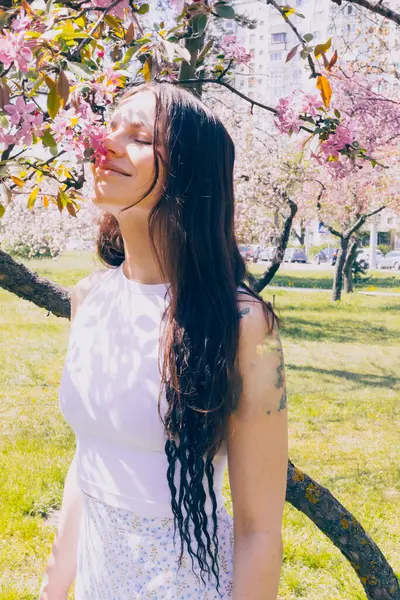 Kyiv 'deki Sakura bahçe parkında beyaz elbiseli güzel bir kadın.