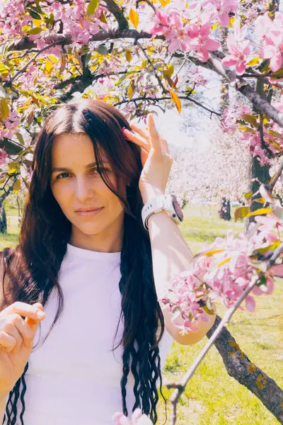 Kyiv 'deki Sakura bahçe parkında beyaz elbiseli güzel bir kadın.