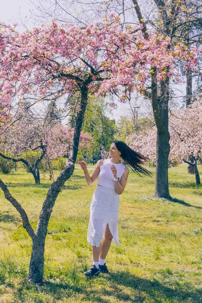 Kyiv 'deki Sakura bahçe parkında beyaz elbiseli güzel bir kadın.