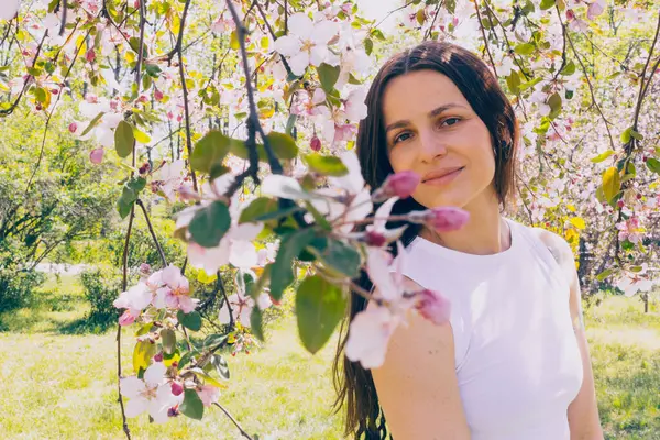 Kyiv 'deki Sakura bahçe parkında beyaz elbiseli güzel bir kadın.