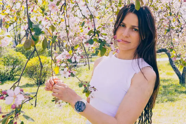 Kyiv 'deki Sakura bahçe parkında beyaz elbiseli güzel bir kadın.