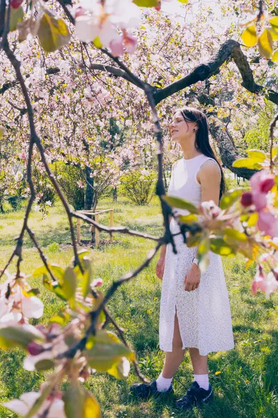 Kyiv 'deki Sakura bahçe parkında beyaz elbiseli güzel bir kadın.