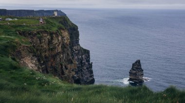 İrlanda 'daki Moher Kayalıkları' nın engebeli kıyı şeridi ve bulutlu gökyüzü manzarası