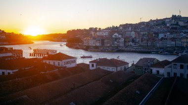 Porto, Portekiz - 24 Temmuz 2025: Porto 'nun tarihi mimarisi ve hareketli nehir manzarası altın bir parıltıyla