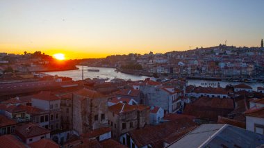 Porto, Portekiz - 24 Temmuz 2025: Porto 'nun tarihi mimarisi ve hareketli nehir manzarası altın bir parıltıyla