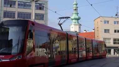 Bratislava, Slovakya - 6 Ağustos 2025: Geleneksel kırmızı tramvay Bratislava merkezinden geçiyor