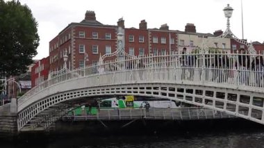 Dublin, İrlanda - 2 Ağustos 2025: Ha penny Köprüsü, beyaz, kemerli, dökme demir, yaya köprüsü, bir yaz günü Liffey Nehri 'ni kapsar.