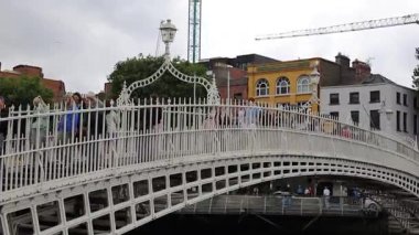 Dublin, İrlanda - 2 Ağustos 2025: Ha penny Köprüsü, beyaz, kemerli, dökme demir, yaya köprüsü, bir yaz günü Liffey Nehri 'ni kapsar.