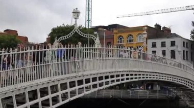 Dublin, İrlanda - 2 Ağustos 2025: Ha penny Köprüsü, beyaz, kemerli, dökme demir, yaya köprüsü, bir yaz günü Liffey Nehri 'ni kapsar.