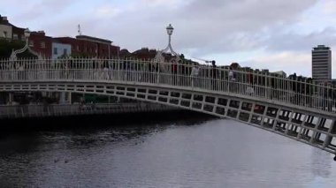 Dublin, İrlanda - 2 Ağustos 2025: Ha penny Köprüsü, beyaz, kemerli, dökme demir, yaya köprüsü, bir yaz günü Liffey Nehri 'ni kapsar.