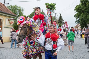 VLCNOV, CZECH REPUBLIC - 29 Mayıs 2022: Geleneksel Moravya folklor kostümü giymiş genç adam, Çek Cumhuriyeti 'nin başkenti Vlcnov' da düzenlenen Kings Ride of the Kings festivali sırasında Acemileri seslendirdi.