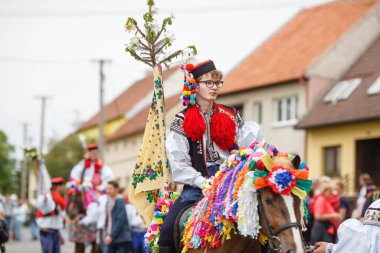VLCNOV, CZECH REPUBLIC - 29 Mayıs 2022: Geleneksel Moravya folklor kostümü giymiş genç adam, Çek Cumhuriyeti 'nin başkenti Vlcnov' da düzenlenen Kings Ride of the Kings festivali sırasında Acemileri seslendirdi.