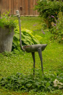 Bahçe dekoru. Çimlerin üzerinde çiçek olan figür. Peyzaj ve bahçe dekorasyonu.