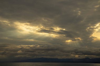 Günbatımı gökyüzü arkaplanı. Akşam gökyüzü bulutlarıyla birlikte dramatik günbatımı gökyüzü parlak güneş ışığıyla aydınlatılıyor - doğal günbatımı manzarası. 