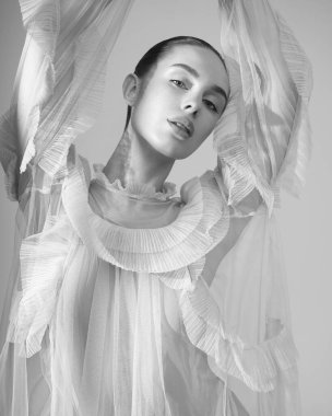 young beautiful girl posing in a romantic dress. Sunlight. Sexy model in transparent dress.