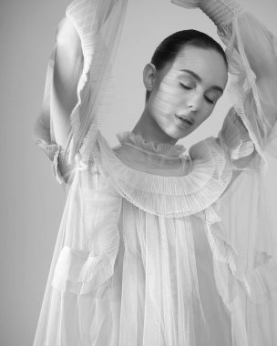 young beautiful girl posing in a romantic dress. Sunlight. Sexy model in transparent dress.