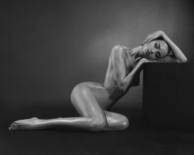 Art portrait of beautiful nude woman. Sexy yong lady with perfect body. Naked slender model posing in a photo studio.