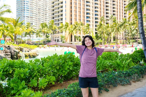 ハワイ旅行に興奮した若い女性リゾートビルが立ち並ぶ腕 — ストック写真