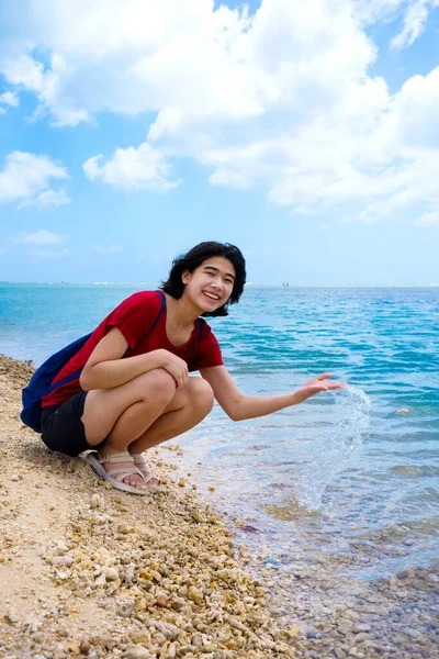 ハワイの静かな湾の海岸に沿って水に触れるために曲げ若い女性 — ストック写真