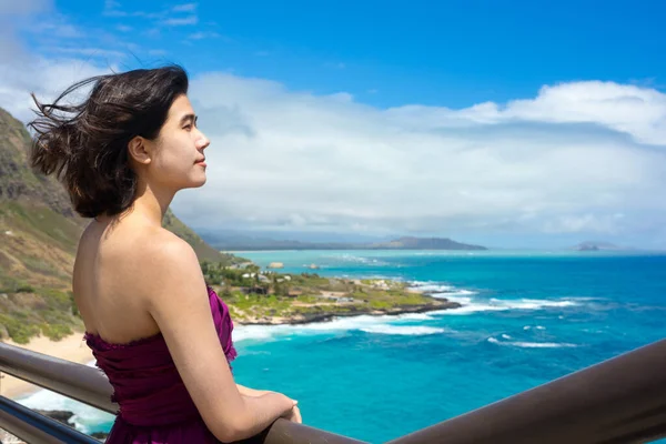 ハワイ オアフ島のマカプのビーチとハワイの海を見下ろすマカプのビューポイントに立っている正式な紫色のドレスの若い女性 ロイヤリティフリーのストック画像