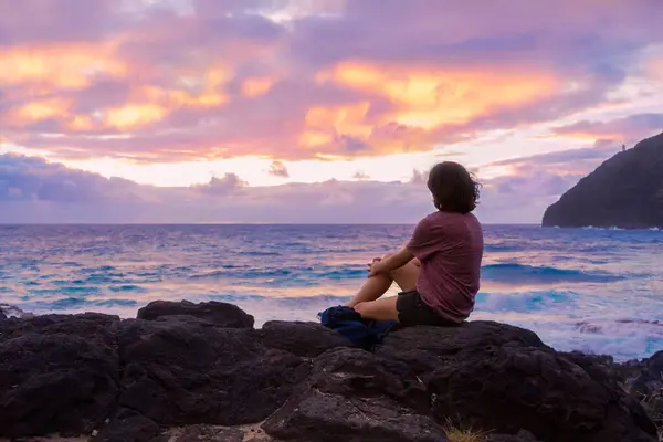 Young Woman Sitting Rocky Beach Watching Sun Rise Hawaiian Ocean Imagem De Stock