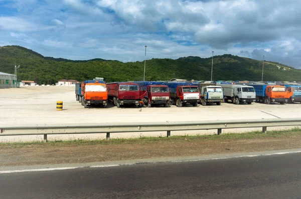 道路上の休憩 青い曇りの空の下に駐車するさまざまな物流会社のトラック ストック写真