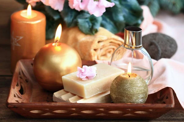 ゴールドとピンクのキャンドルとスパのコンセプト 木製のテーブルの上に手作りのオリーブ石鹸 洗顔料 タオル キャンドル ピンクのシクラメン — ストック写真