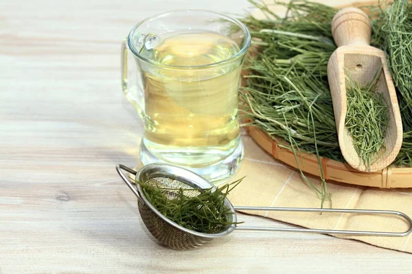 Equisetum Arvense 'den bitkisel çay, at kuyruğu ya da sıradan bir at kuyruğu, ahşap masanın üzerindeki sepetteki kurutulmuş bitki. Geleneksel tıpta kullanılır, silikon bakımından zengindir.. 