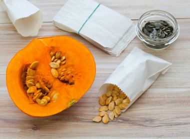 Balkabaklarından kendi tohumlarını alıyorlar. Kurumuş Hokaido kabağı tohumları kese kağıdında, yeşil tohumlar yağ kabağının arkasında..