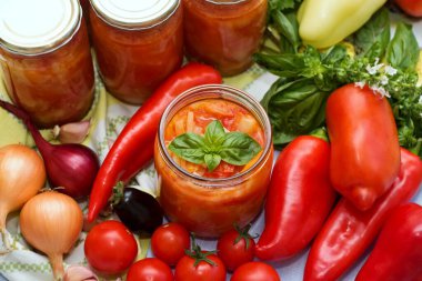 Ev yapımı konserve domates ve biber sosu. Taze sebze ve baharatlar. Sarımsak, soğan, fesleğen, kırmızı biber ve farklı türde domates.. 