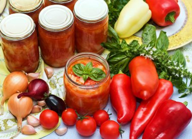 Ev yapımı konserve domates ve biber sosu. Taze sebze ve baharatlar. Sarımsak, soğan, fesleğen, kırmızı biber ve farklı türde domates.. 