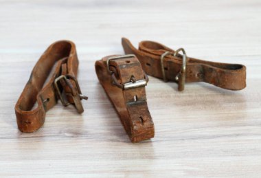Kayakları bağlamak için kullanılan eski deri kayışlar. Ahşap masada doğal deri kemerler.. 
