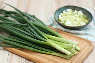 Kesme tahtasında ve kasede taze taze soğan. Ev yapımı organik yeşil soğanlar vitamin dolu..