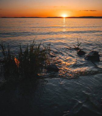 Yazın Balaton Gölü 'nün üzerinde renkli gün batımı