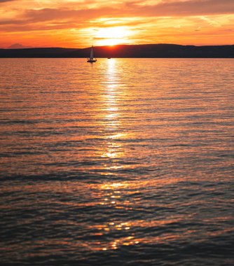 Yazın gün batımında Balaton Gölü 'nde yelkenli.