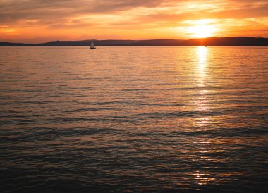 Yazın gün batımında Balaton Gölü 'nde yelkenli.