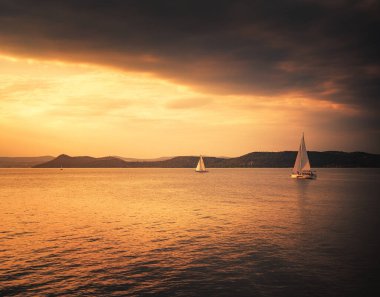 Yazın gün batımında Balaton Gölü 'nde yelkenli.