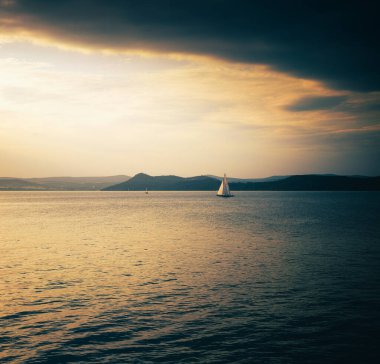 Yazın gün batımında Balaton Gölü 'nde yelkenli.