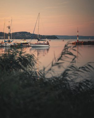 Yazın gün batımında Balaton Gölü 'nde yelkenli.