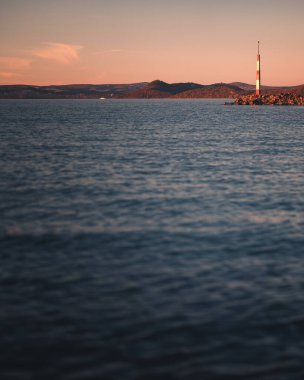 Balaton Gölü 'nün Üzerinde Gece Işığı Seyrüsefer feneri ve Uzak Tepeler
