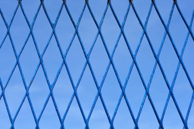 Mavi elmas şekilli çitin ayrıntıları mavi gökyüzüne karşı