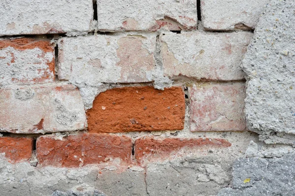 Stock image Detail of an old wall with cracked fasade and bricks underneath