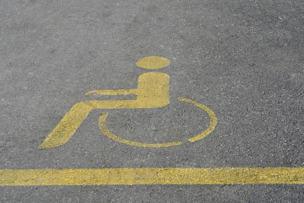 Illustration of a yellow man in a wheelchair indicating a parking space for people with disabilities