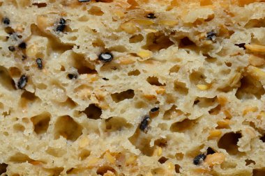 Keten tohumları ve siyah susam tohumlarıyla bir dilim ekmeğin detaylarını kapat.